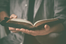 Dirty Hands Holding An Old Bible. Very Short Depth-of-field