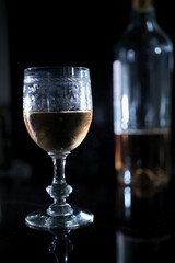 Wall Mural - Vertical closeup shot of a glass of wine on a table with a blurred background