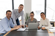© fizkes - Business team of happy diverse employees looking at camera at workplace. Group of mixed race managers posing for corporate portrait during meeting and discussion of work success. Teamwork concept