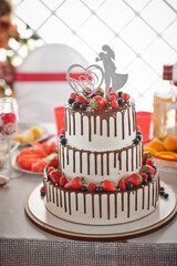 Wall Mural - A big cake with streaks of chocolate and natural strawberries and blueber