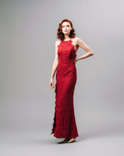 Valentine's Day Look Idea. Sexy Ginger Woman In Bright Red Jumpsuit. Women’s Clothing, Fashion Concept. Burgundy Evening Gown. Sensual Portrait. Natural Looking Makeup And Wavy Hair.