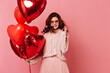 © Look! - Excited european girl posing with heart shaped balloons. Studio shot of wonderful ginger woman isolated on pink.