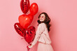 © Look! - Studio shot of sensual ginger girl with red heart shaped balloons. Indoor photo of beautiful woman isolated on pink.