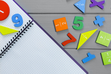 Close up mathematical fractions and notebook on gray background. Creative, fun mathematics banner. Education, back to school concept