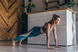 © undrey - Fit woman doing full plank exercise, workout at home.