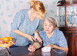 © Дворецкая Таня - A young woman measures the blood pressure of an elderly woman