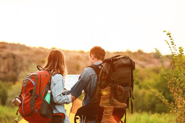 Wall Mural - Couple of young tourists with map in countryside