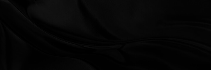 Black gray satin dark fabric texture luxurious shiny that is abstract silk cloth panorama background with patterns soft waves blur beautiful.