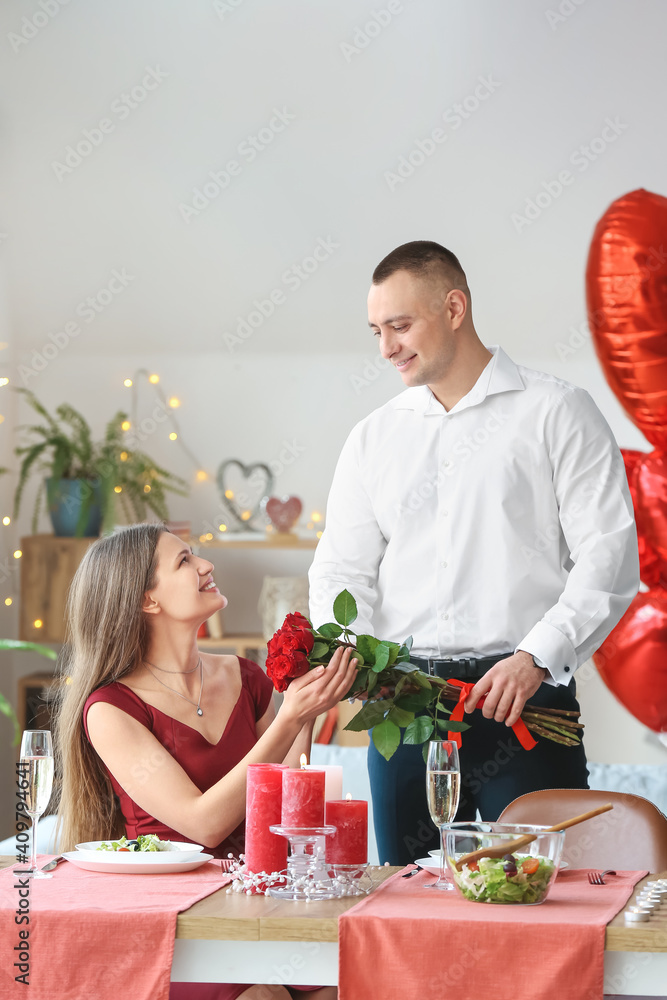 Young man greeting his girlfriend on Valentine's Day at home