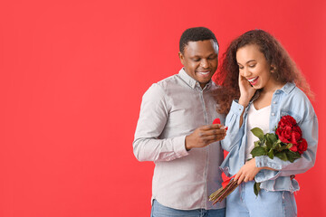 African-American man proposing to his beloved on color background