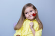 valentine's day caucasian child holding a lollipop heart over grey background.Donation,heart health,world heart day, world health day,world mental health day.Health and heart concept.