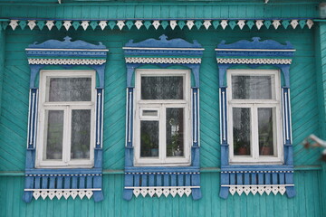 Ornamental windows with carved frames on vintage wooden rural house in Ivanovo city, Russia. Building facade. Russian traditional national folk style in architecture. Russian landmark, Ivanovo sight