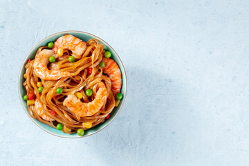 Wall Mural - Noodles, stir-fried with shrimps and vegetables, overhead shot with a place for text