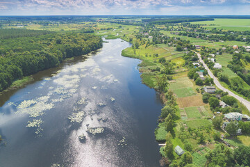 Wall Mural - Top view of a river in the countryside on a sunny day. Nature landscape with a beautiful cloudy sky. In summer