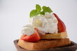 Belgian waffles with strawberries, whipped cream and mint leaves. Tasty dessert concept