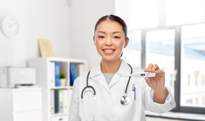 Wall Mural - medicine, profession and healthcare concept - happy smiling asian female doctor with stethoscope and thermometer over medical office at hospital on background