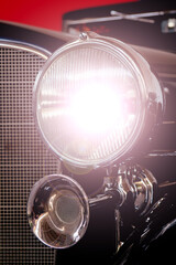 Poster - Vertical shot of a headlight of an antique vitage car