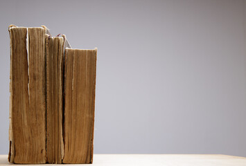  Close-up of several old and antique books arranged in rows. Bookshelf - Selective focus background with shallow depth of field.