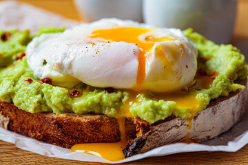 avocado toast with poached egg on wooden board. breakfast concept.