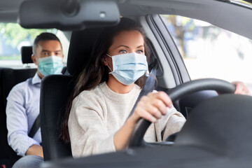 transportation, health and people concept - female driver driving car with male passenger wearing face protective medical mask for protection from virus disease