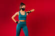 © Viorel - Caucasian fitness girl wearing a protective mask looks at her achievements on a fitness watch during training. Sports during quarantine. Red background and side advertising space.