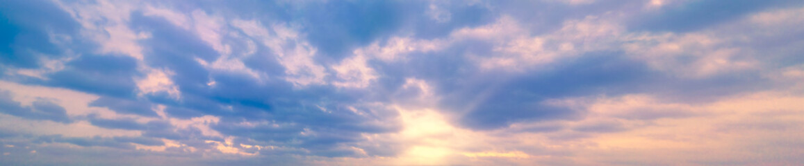 panoramic sky with yellow winter sun and stratocumulus clouds. a panorama of the cold blue sunset sk