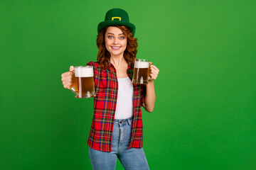 Portrait of her she nice attractive pretty cheerful cheery glad wavy-haired girl in checked shirt offering giving you beer isolated on bright vivid shine vibrant green color background