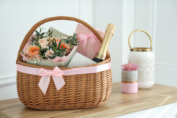 Wicker basket with gifts on table indoors