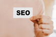 © Daria Lukoiko - Man holding a business card with SEO