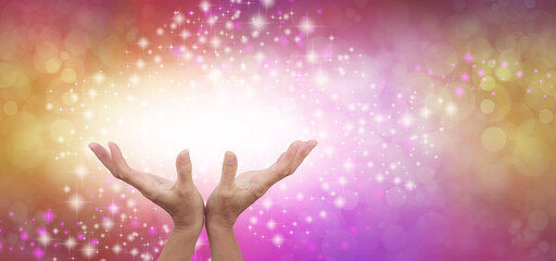 Wall Mural - Connecting to High Frequency Reiki Universal Healing Energy - female cupped hands reaching up into a beautiful white light against a gold and pink energy field background with sparkles and white light