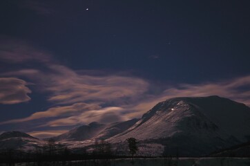 floating clouds over snowy mountain peak