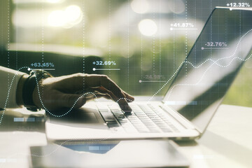 Double exposure of abstract creative statistics data hologram with hands typing on laptop on background, analytics and forecasting concept