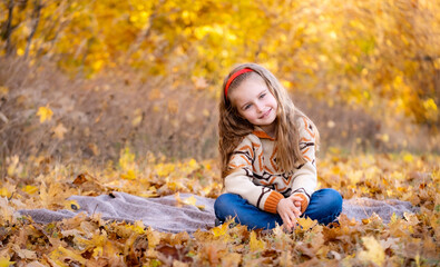 Cheerful school girl in autumn park