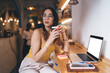 © BullRun - Skilled student with coffee to go in hand thinking during laptop e learning on technology with copy space area for advertising text, millennial freelancer pondering at table with mock up netbook