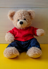 Wall Mural - Teddy bear with red tshirt sitting on the floor, child room