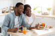 © Prostock-studio - Cheerful Black Couple Using Digital Tablet In Kitchen While Having Breakfast