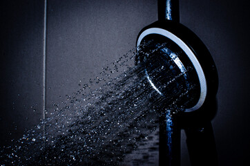 Shower rain water in bathroom, black and dark blue tone. Close up shot.