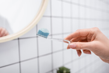 Wall Mural - cropped view of woman holding toothbrush with toothpaste in hand