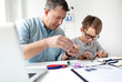 © epiximages - Father and son repairing an electrical outlet.