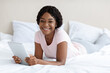 © Prostock-studio - Pretty black woman with digital tablet, bedroom interior