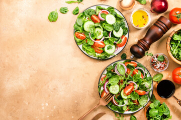 Wall Mural - Spring green salad with spinach, cherry tomatoes, corn salad and red onion. Healthy food concept. Beige stone table. Top view. Copy space