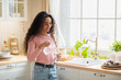 © Prostock-studio - Young Beautiful Woman Drinking Water In Kitchen At Home