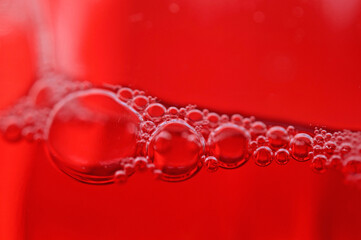 Canvas Print - Macro shot of soap bubbles on red background