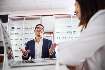 Male client talking to a woman optician