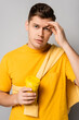 © LIGHTFIELD STUDIOS - Man looking at camera while holding takeaway drink on grey background