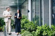 © DragonImages - Serious business colleagues walking on the street and discussing details of project they are working on