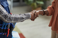 Close Up Of Unrecognizable African-American Woman Shaking Hands With Handyman Standing In Home Interior, Copy Space