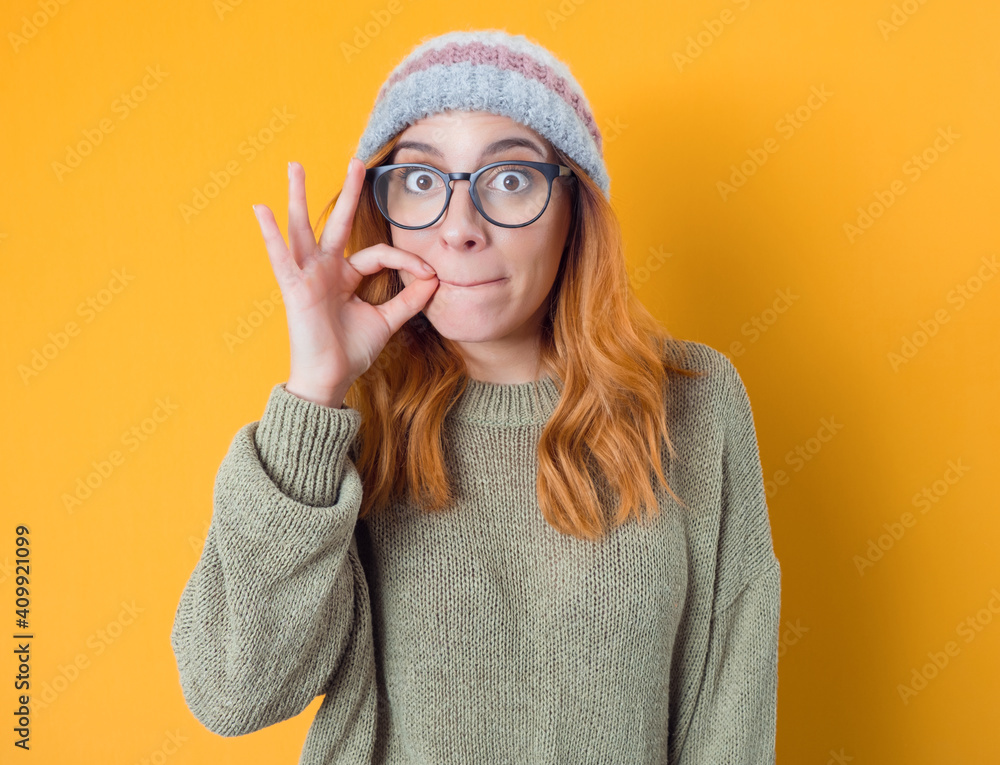 Keep the secret - keep quiet. Young woman keeps closed mouth with her fingers, isolated on white background - obrazy, fototapety, plakaty 