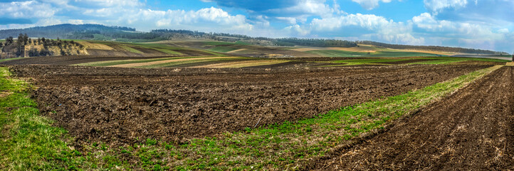 Fotomurales - Beautiful spring wide panorama of arable fields stretching to horizon under clear bright blue sky with on distant hills. Agriculture and farming concept.