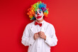 © alfa27 - sad clown stand depressed having painted face make-up, crying during performance, isolated red background